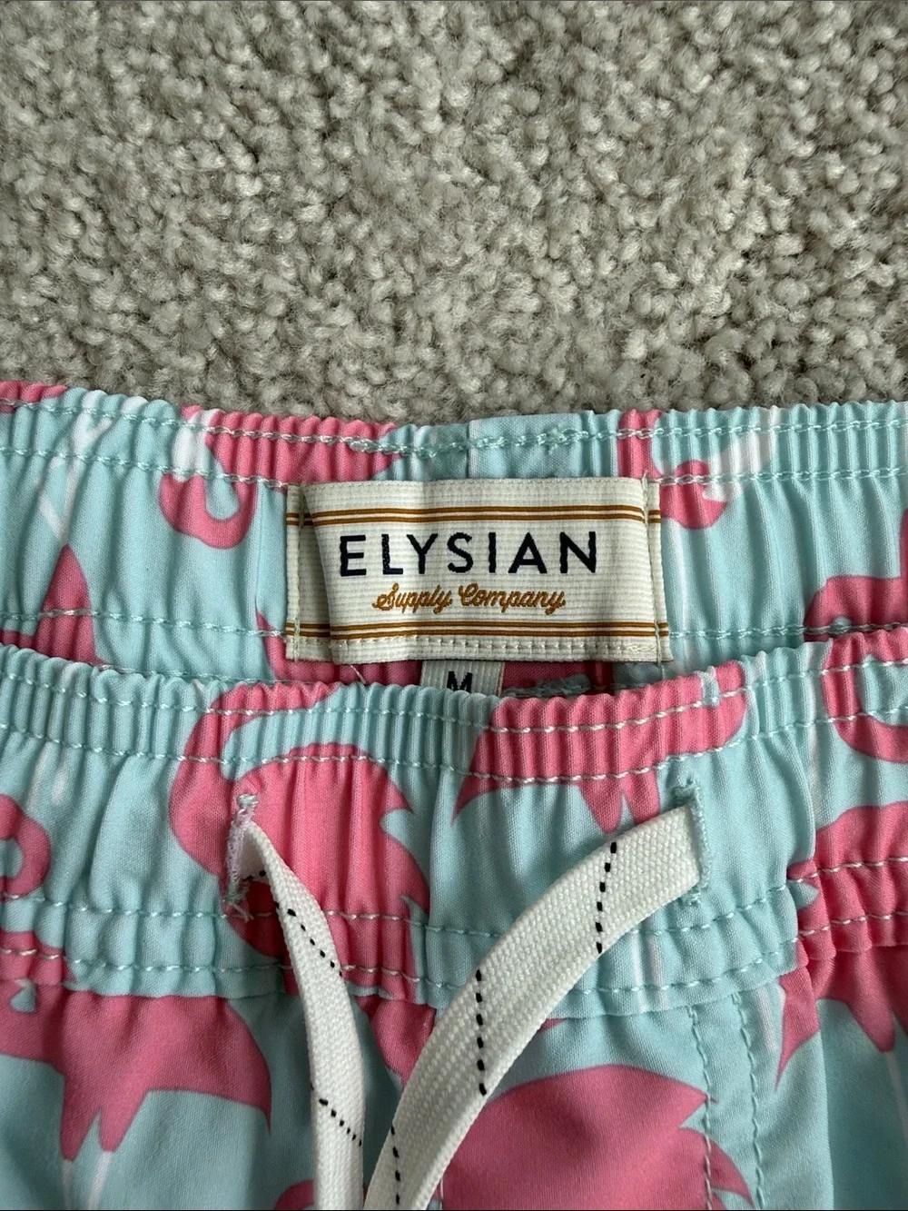 Elysian brand Men’s swim trunks in a blue and pink flamingo print- Size Medium
